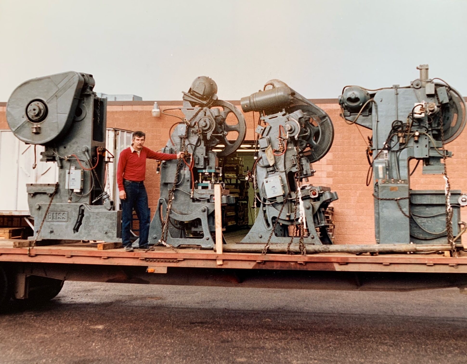Sheldon Ajax atop a truckload of stamping presses purchased by the company to increase stamping capabilities, circa 1960
