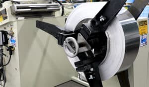 A coil of aluminum on a progressive stamping feeder system at Ajax Metal Forming Solutions