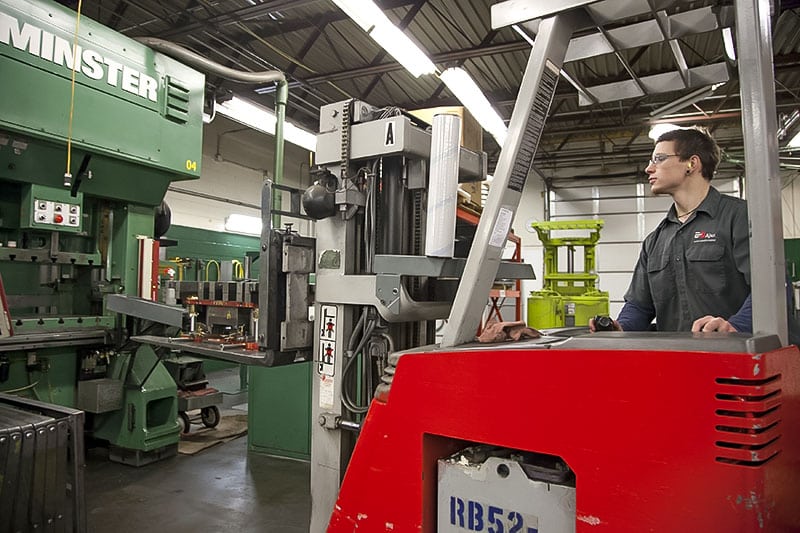 An Ajax colleague loading material onto a Minster 200-ton stamping press line.