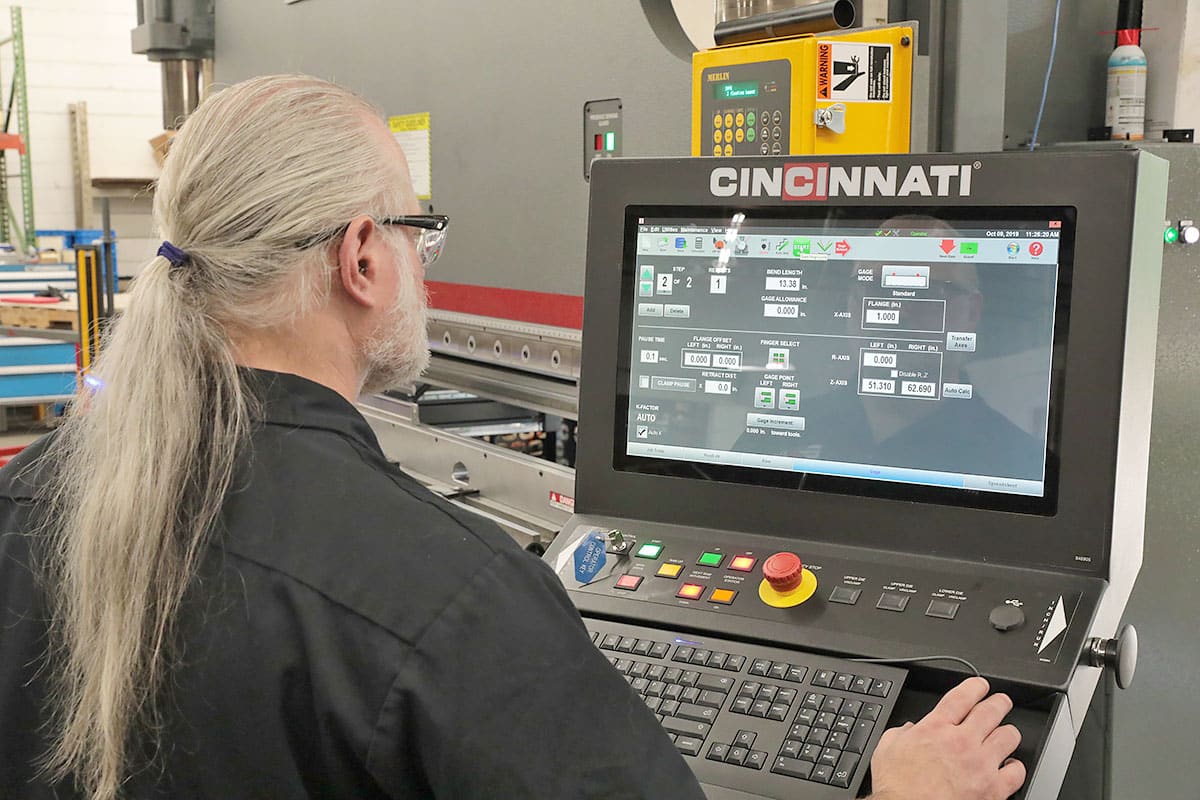 Operating the computer numeric controls (CNC) on a five-axis press brake with a 14-foot bed.