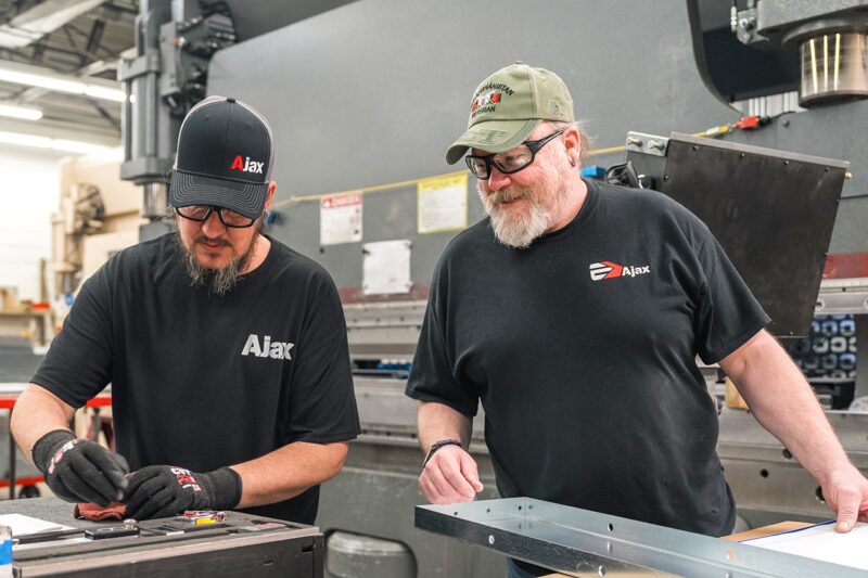 Ajax colleagues check part specifications at the 14-foot Cincinnati press brake.